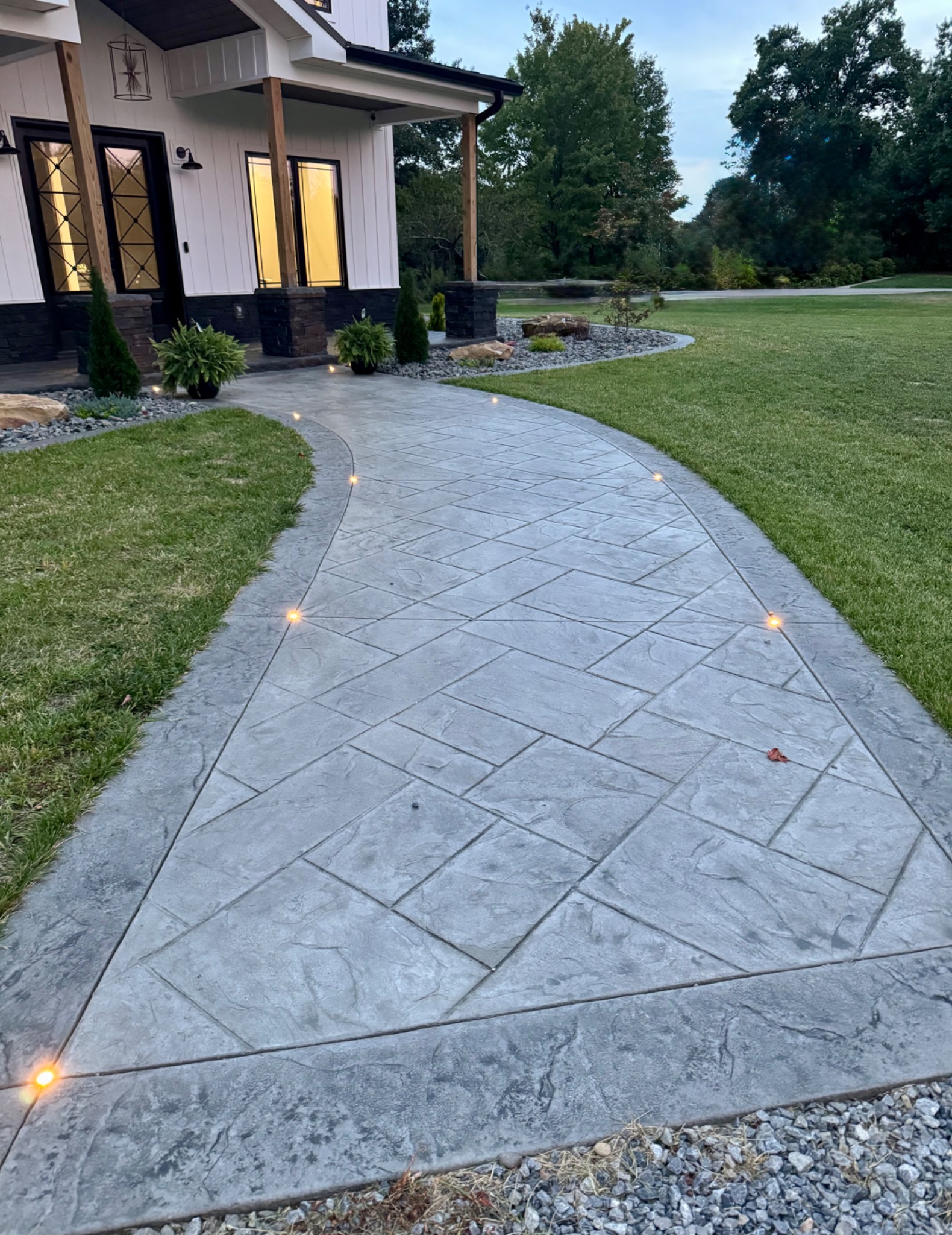 Curved stamped concrete walkway with lighting